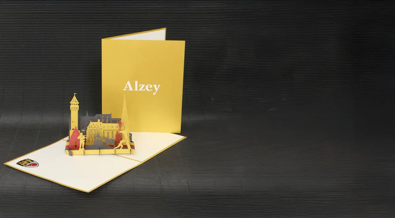 Aufgeklappte goldene 3D-Klappkarte mit Alzeyer Sehenswürdigkeiten als Papierarchitektur